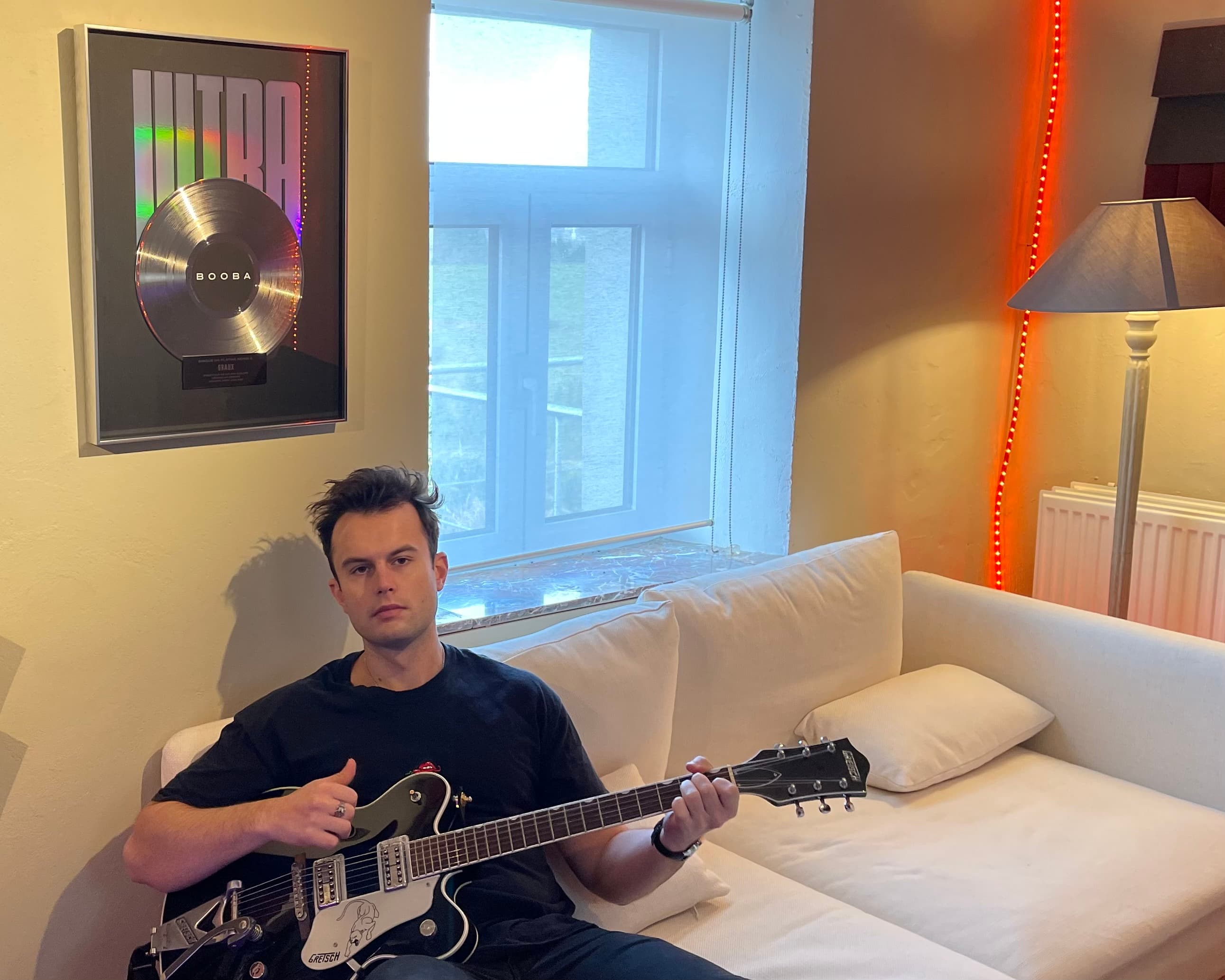 GRAUX dans son studio à Bruxelles avec sa Gretsch devant la plaque Disque de Platine BOOBA · Ultra